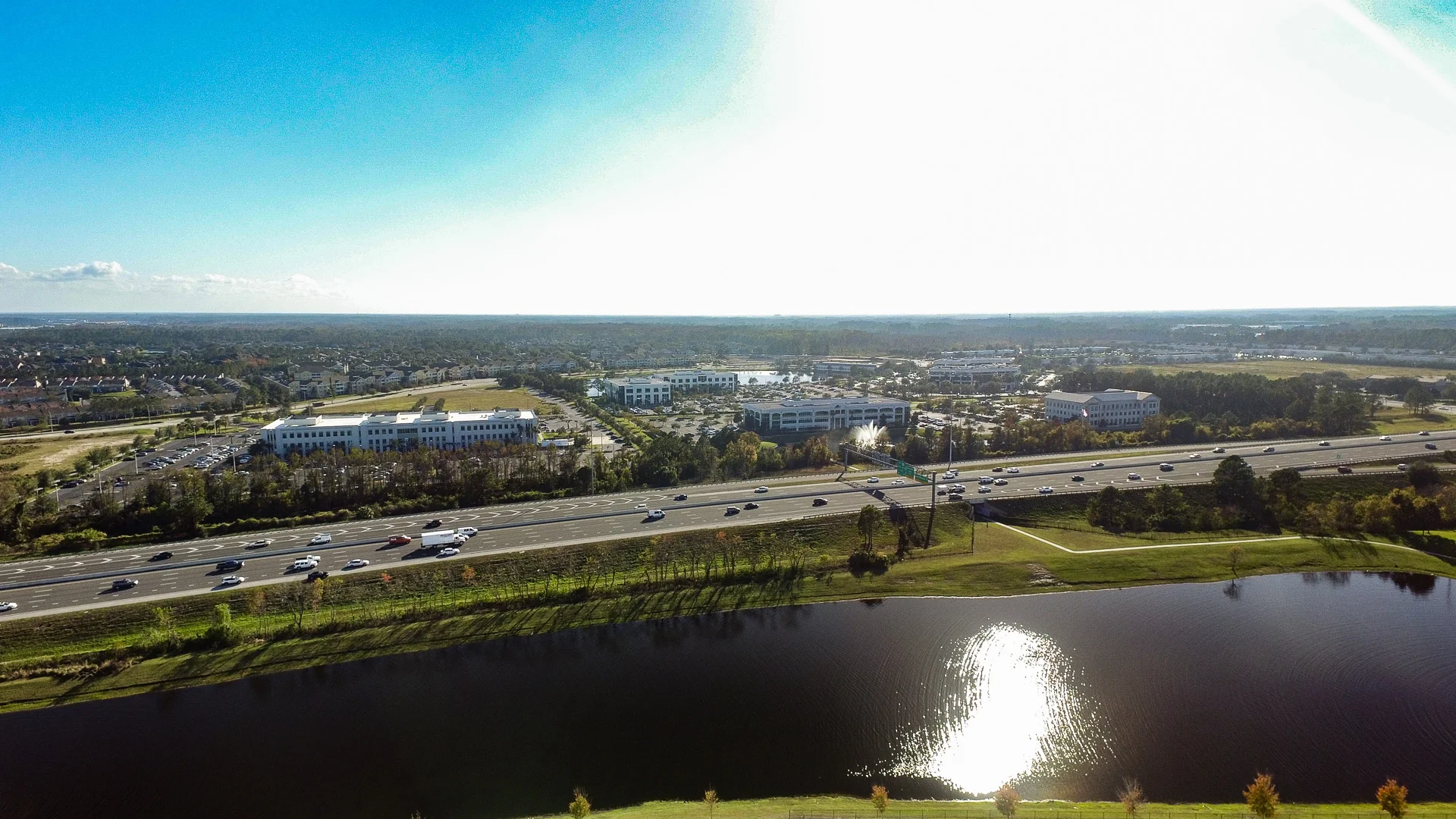 Aerial photograph of Jacksonville roads, offices, trees and a pond.